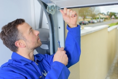 Garage door repair technician servicing a garage door